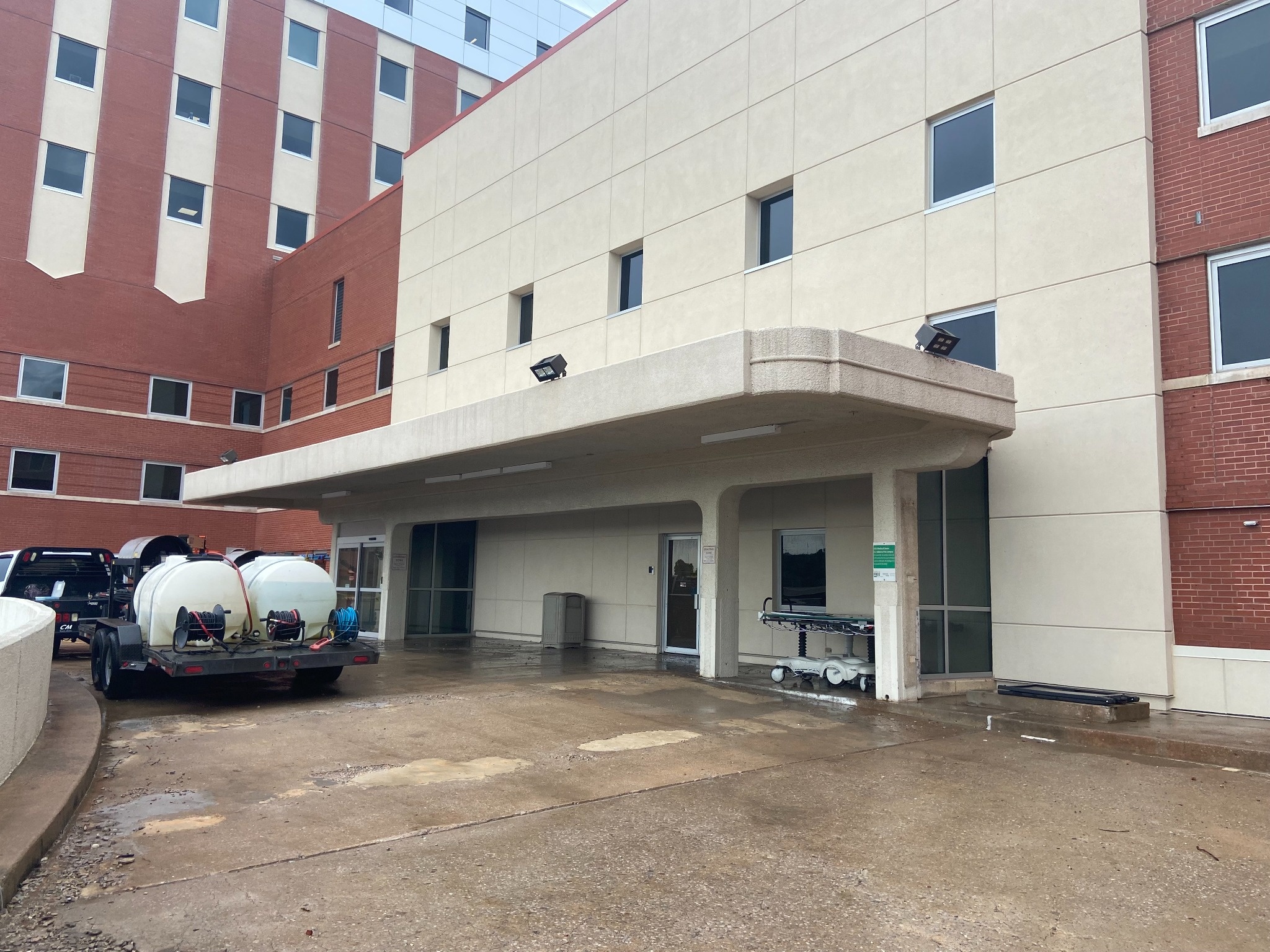 Commercial wash rig and trailer at a building entrance